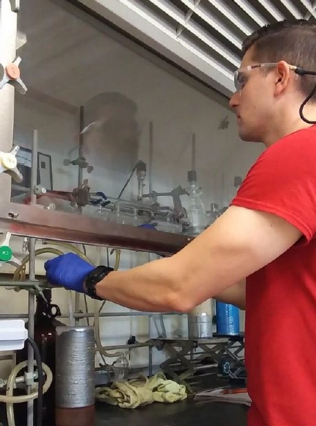 Graduate student working under fume hood in materials chemistry lab