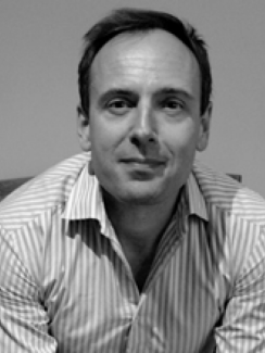 Black-and-white head shot of Prof. Sherburn, dark-haired caucasian man wearing a striped shirt