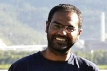 Portrait of Dr. Abishek K. Iyer, speaker, young man with dark hair and beard, taken in an outdoor setting