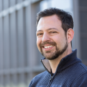Portrait of Prof. Steven Malcolmson, speaker--bearded man in blue shirt outside of lab building